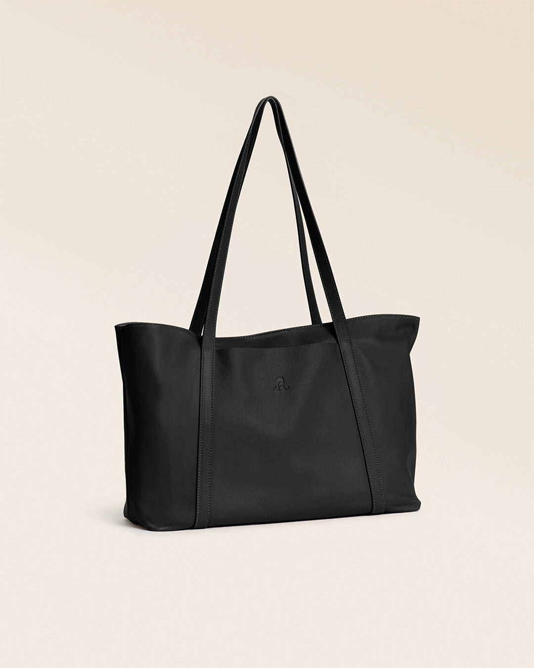 Notre cabas Annette Renouard en cuir lisse noir, vu de quart en studio.