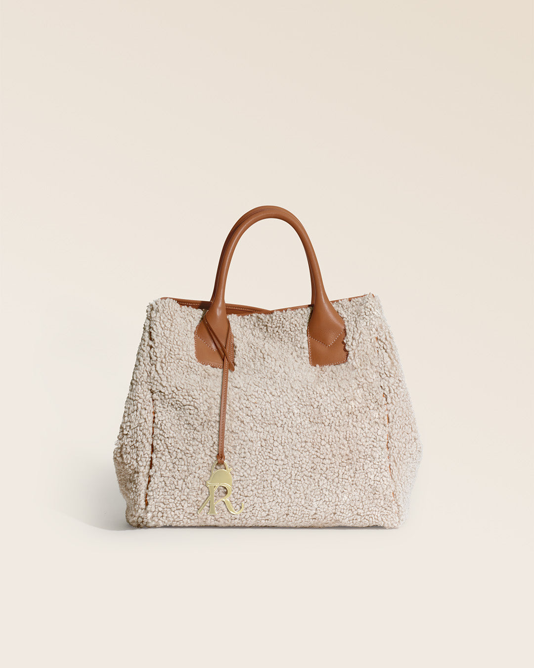 Notre cabas Max Renouard en toile bouclette naturelle et cuir vintage camel, vu de face en studio.