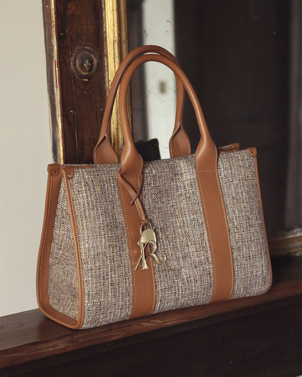 Notre sac cabas Nina Renouard en toile tweed beige et cuir vintage camel, vu en ambiance.