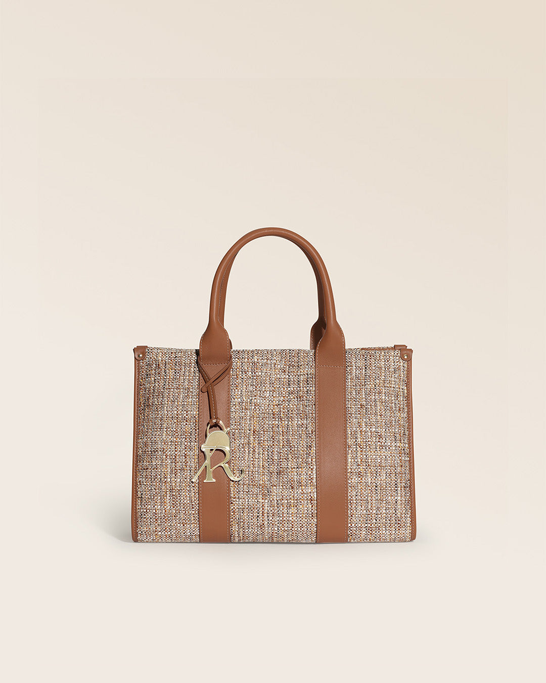 Notre sac cabas Nina Renouard en toile tweed beige et cuir vintage camel, vu de face en studio.