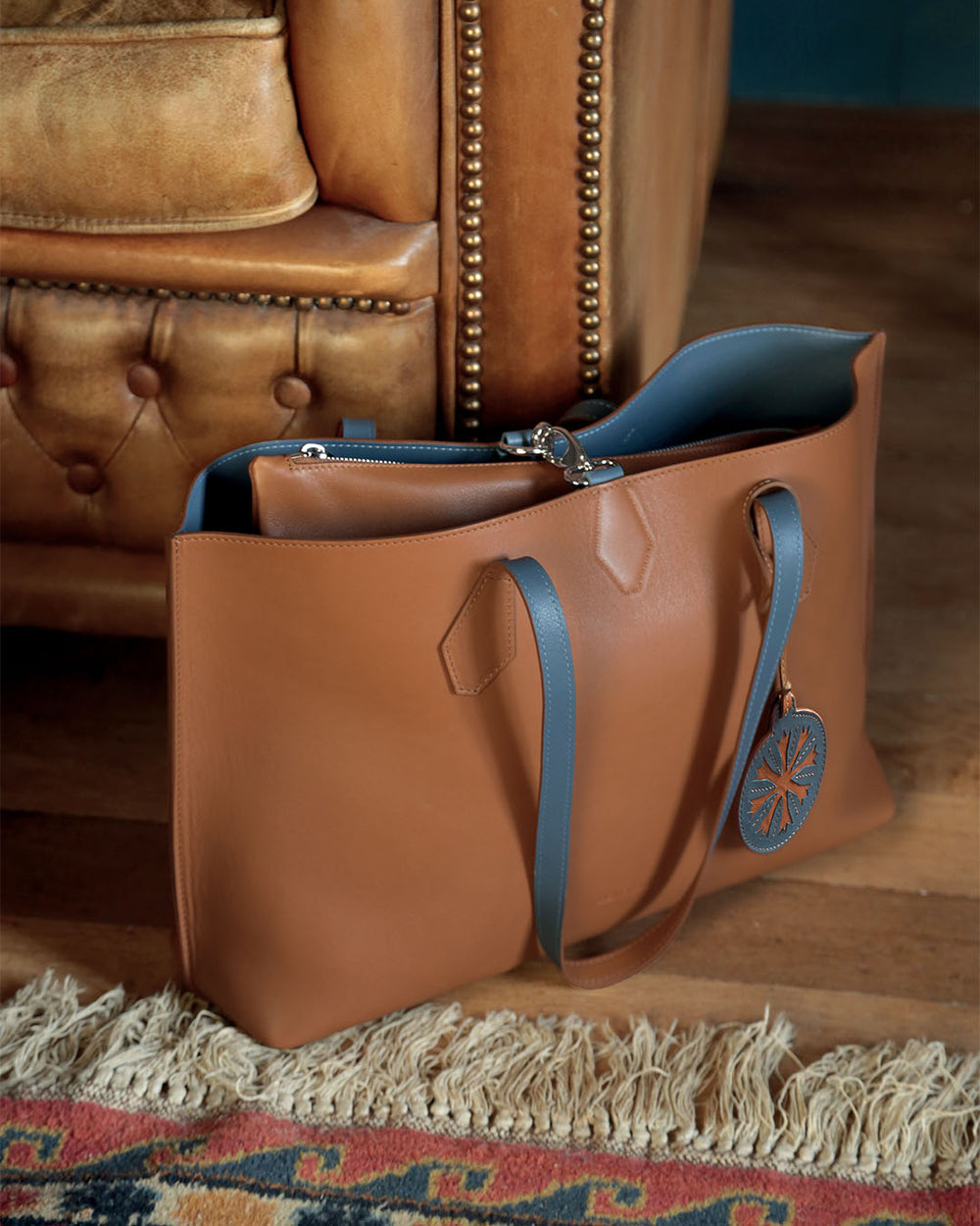 Notre sac cabas Shopper Renouard réversible en cuir vintage camel et vintage jean, vu en ambiance. 