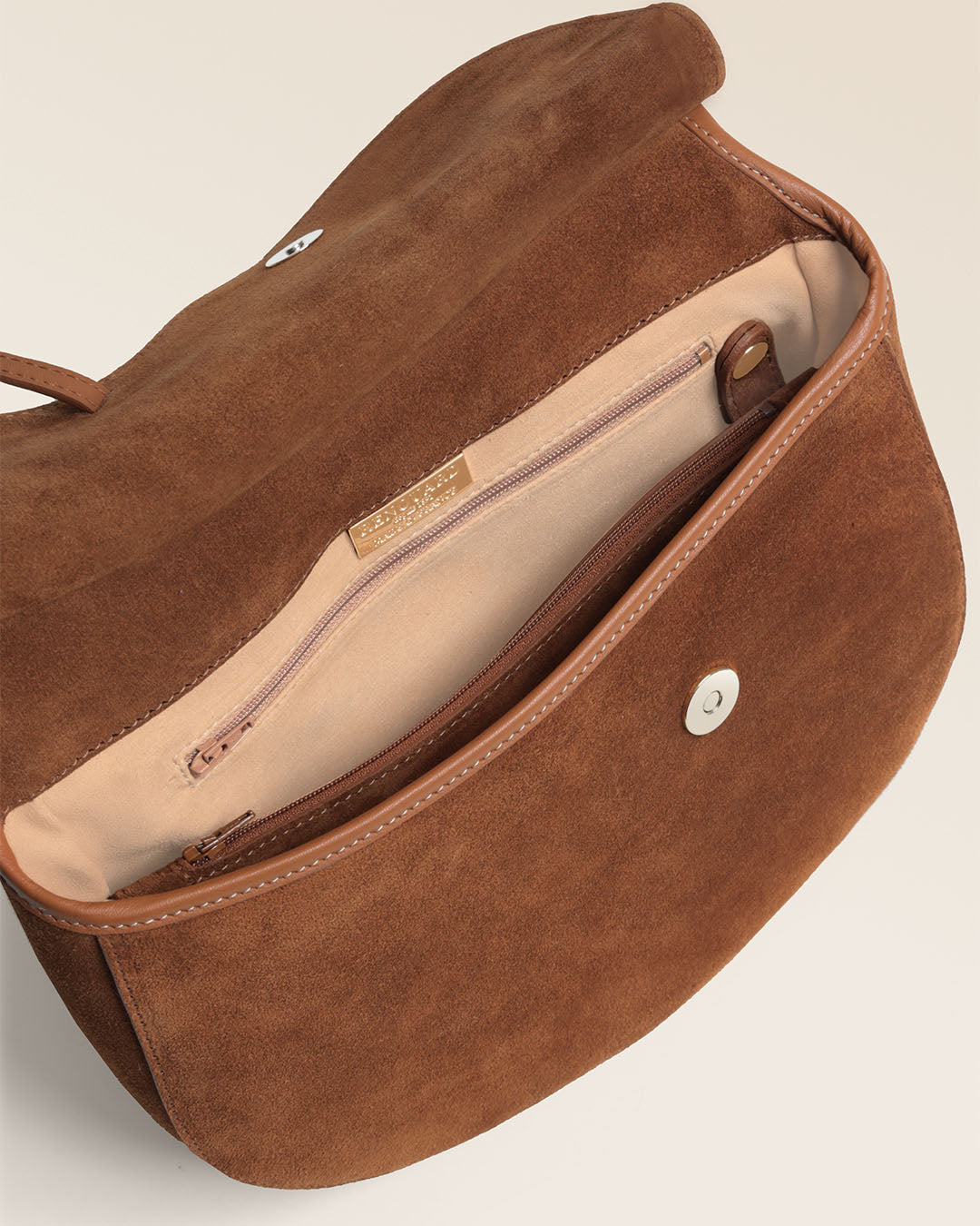 Le sac Cavalerie Renouard en cuir veau velours noisette, cuir lisse camel et sa bandoulière coton camel ; vu ouvert en studio.