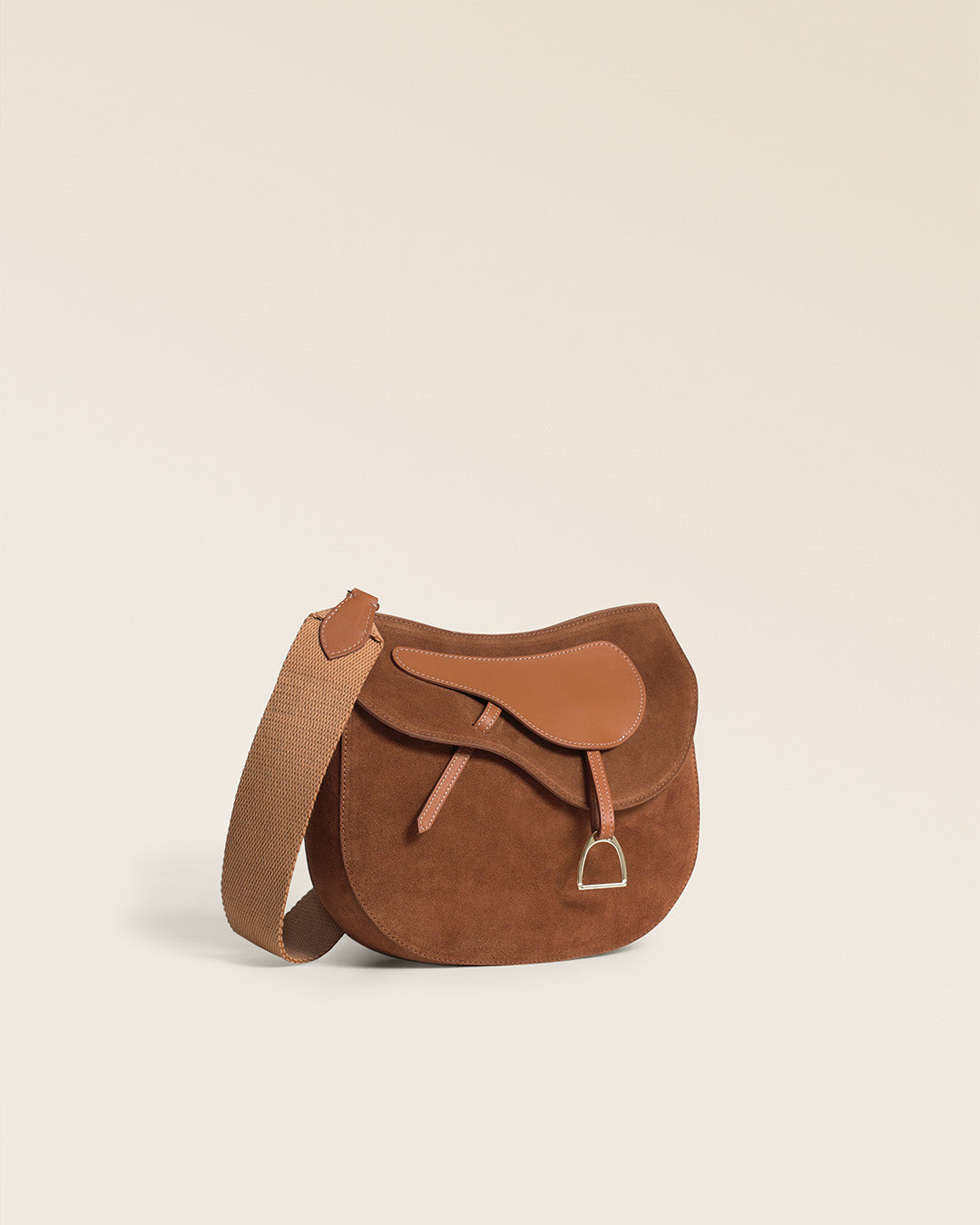 Le sac Cavalerie Renouard en cuir veau velours noisette, cuir lisse camel et sa bandoulière coton camel ; vu de quart en studio.
