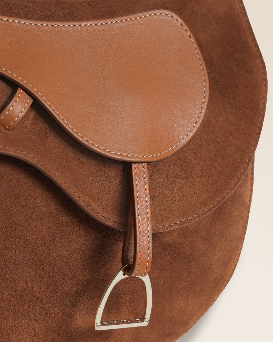 Le sac Cavalerie Renouard en cuir veau velours noisette, cuir lisse camel et sa bandoulière coton camel ; vu en détails en studio.