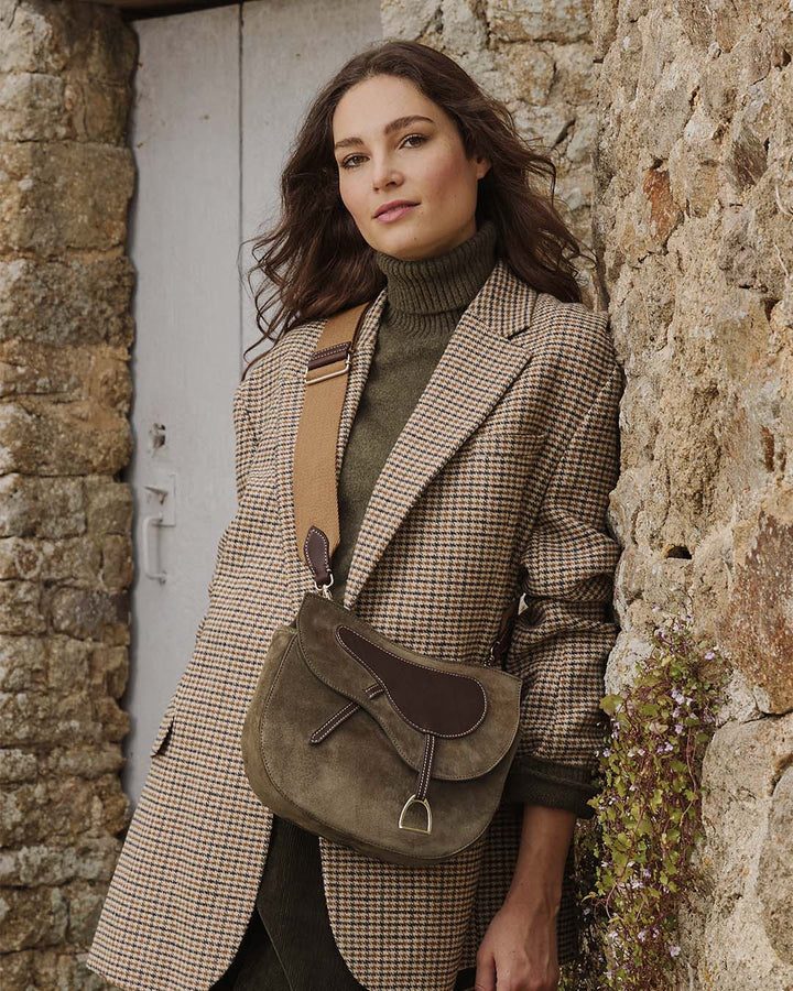 Notre sac Cavalerie Renouard en cuir veau velours truffe avec sa bandoulière en coton, vu porté par notre mannequin. 