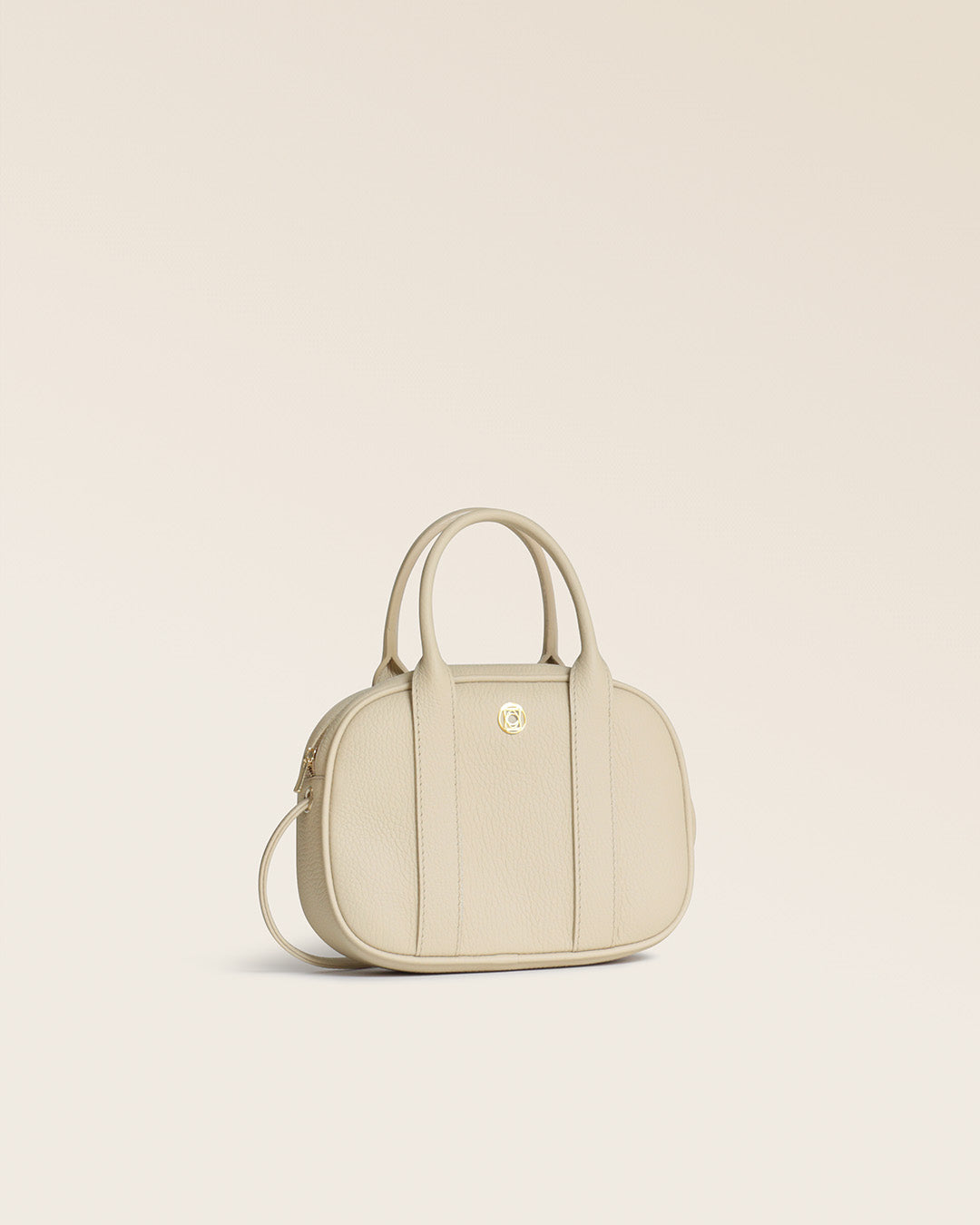 Notre sac Ciao Renouard en cuir façon vigogne crème, vu de quart en studio.