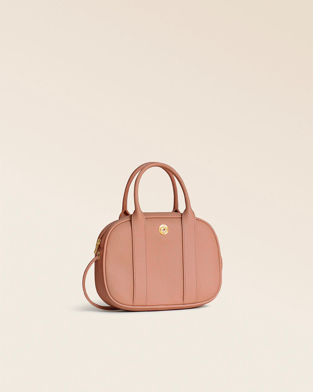 Notre sac Ciao Renouard en cuir façon vigogne pêche, vu de quart en studio.