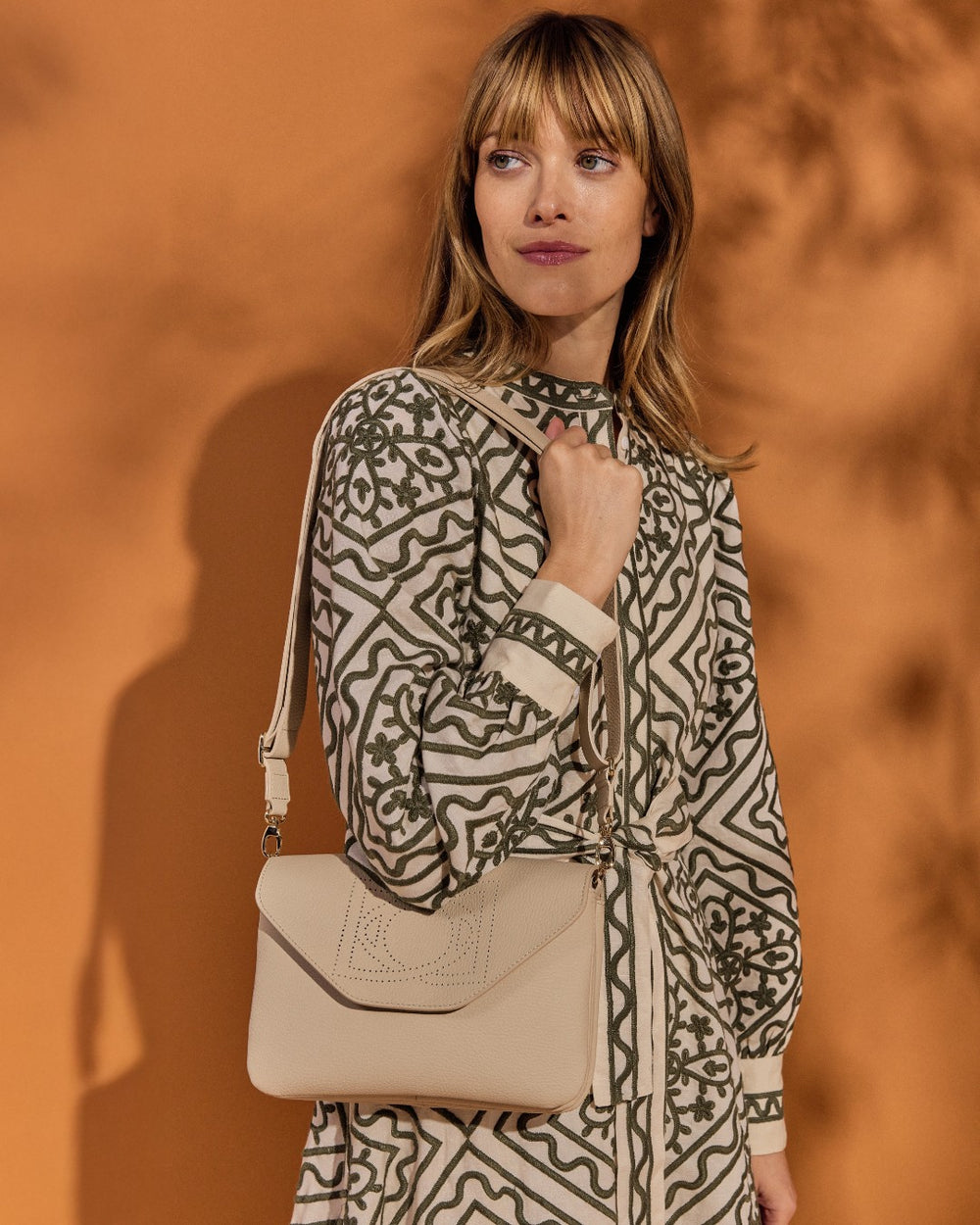 Notre sac Clothilde Renouard en cuir façon vigogne crème, vu porté par notre mannequin. 