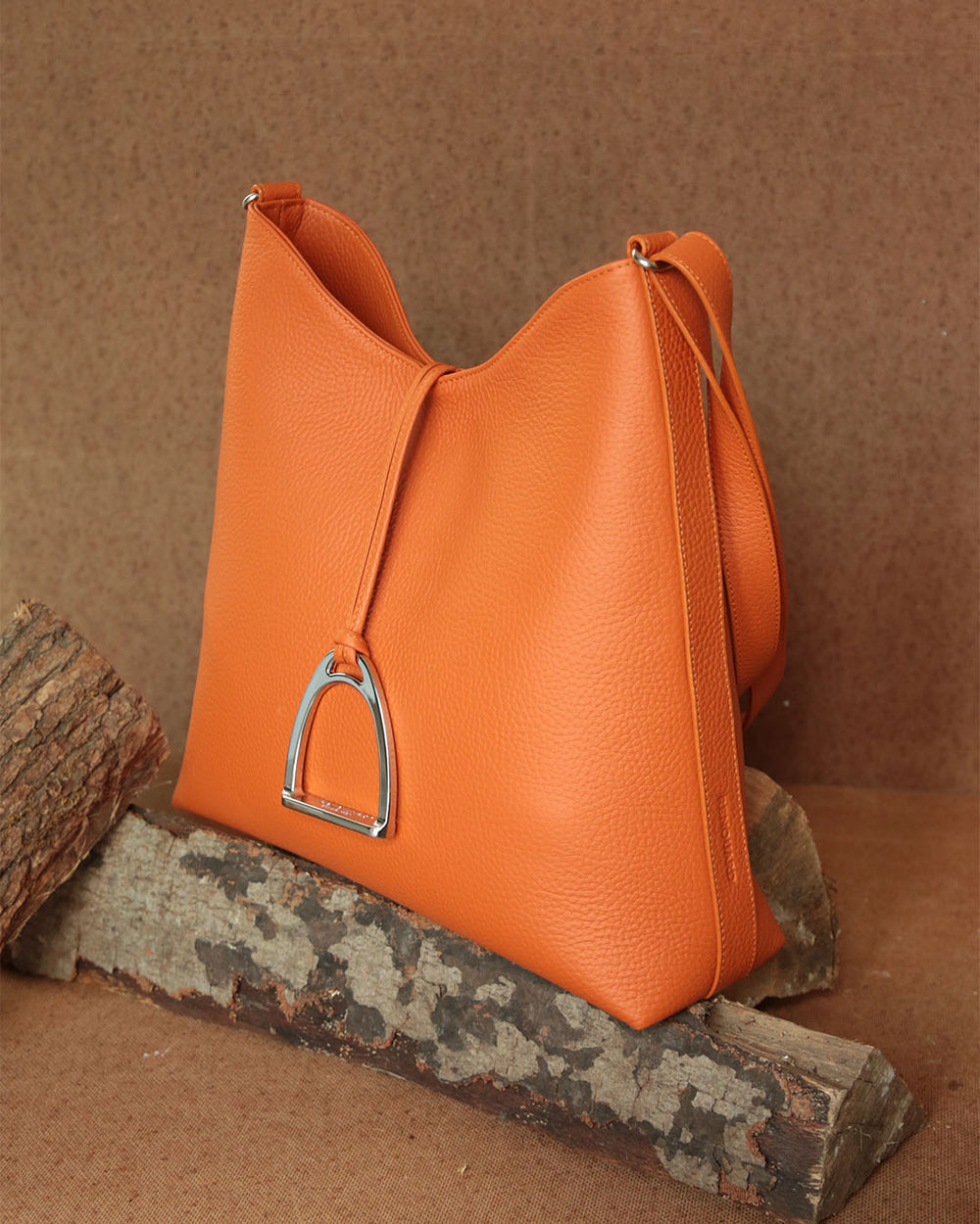Le sac Cob Renouard en cuir façon vigogne orange, vu de quart en ambiance.