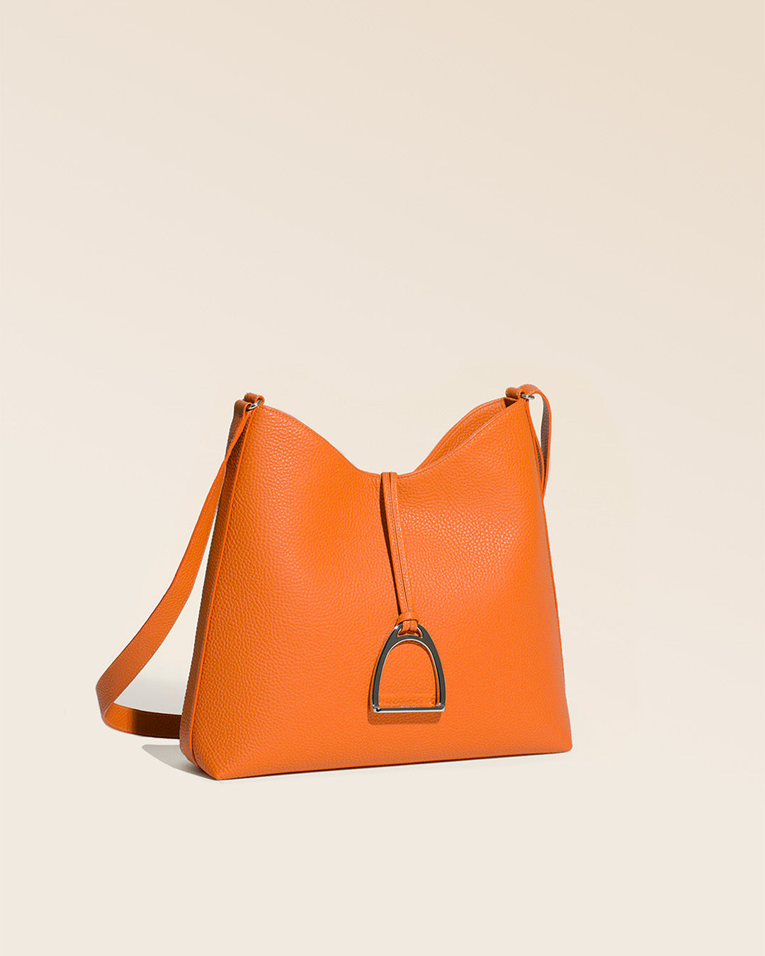 Notre sac Cob Renouard grand modèle en cuir façon vigogne orange vu de quart en studio.
