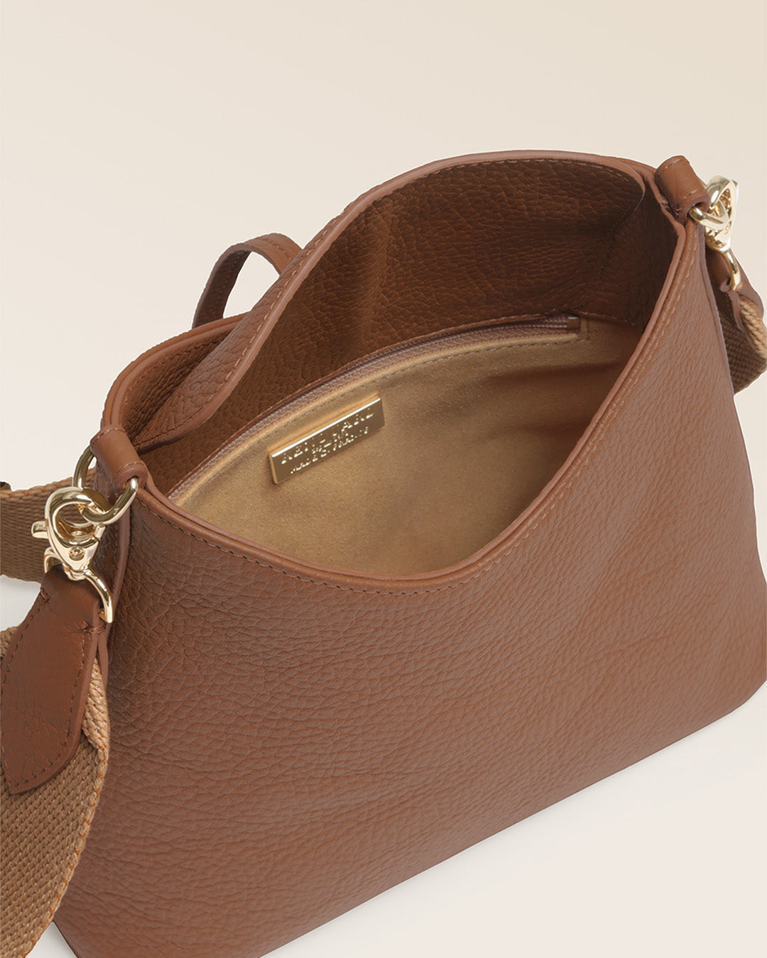 Notre sac Cob Renouard dans sa version Mini modèle, cuir façon vigogne fauve et bandoulière coton ; vu du dessus en studio.