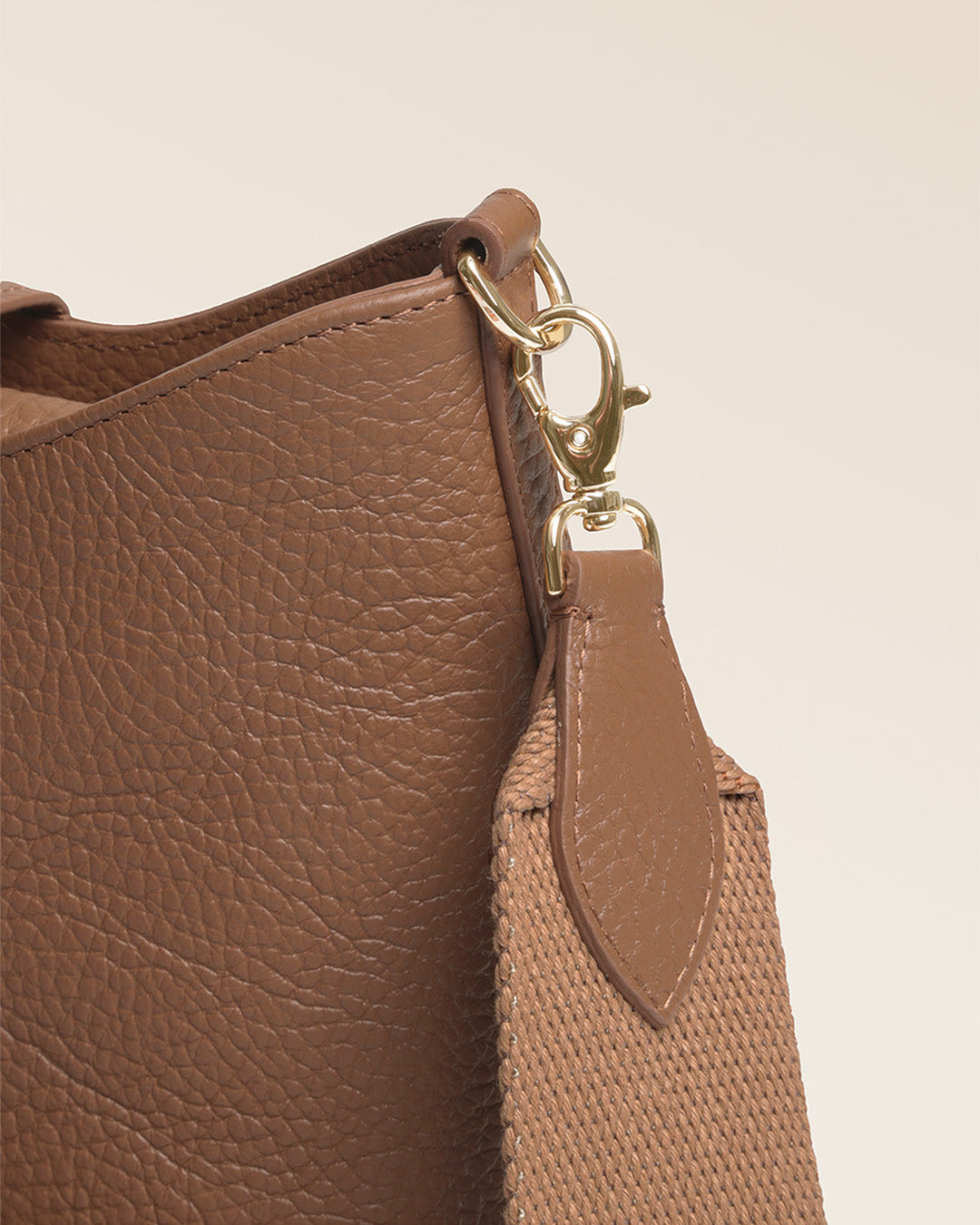 Notre sac Cob Renouard dans sa version Mini modèle, cuir façon vigogne fauve et bandoulière coton ; vu de près en studio.