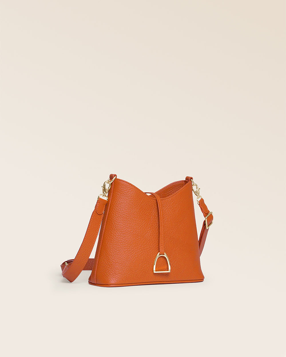 Notre sac Cob Renouard dans sa version Mini modèle, cuir façon vigogne orange et bandoulière cuir ; vu de quart en studio.