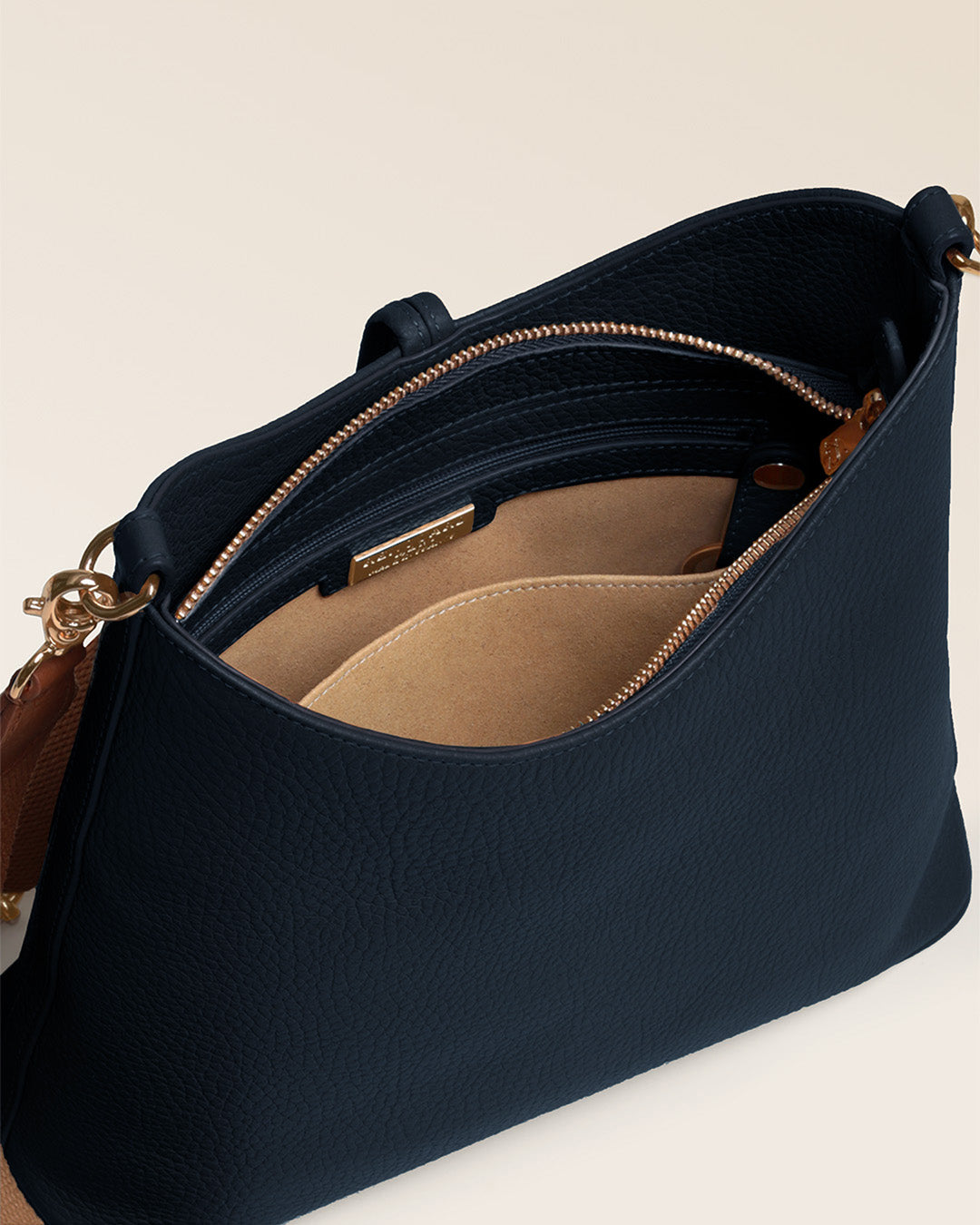 Notre sac Petit Cob Renouard en cuir façon vigogne bleu marine, accessoires dorés et bandoulière cuir ; vu du dessus en studio.