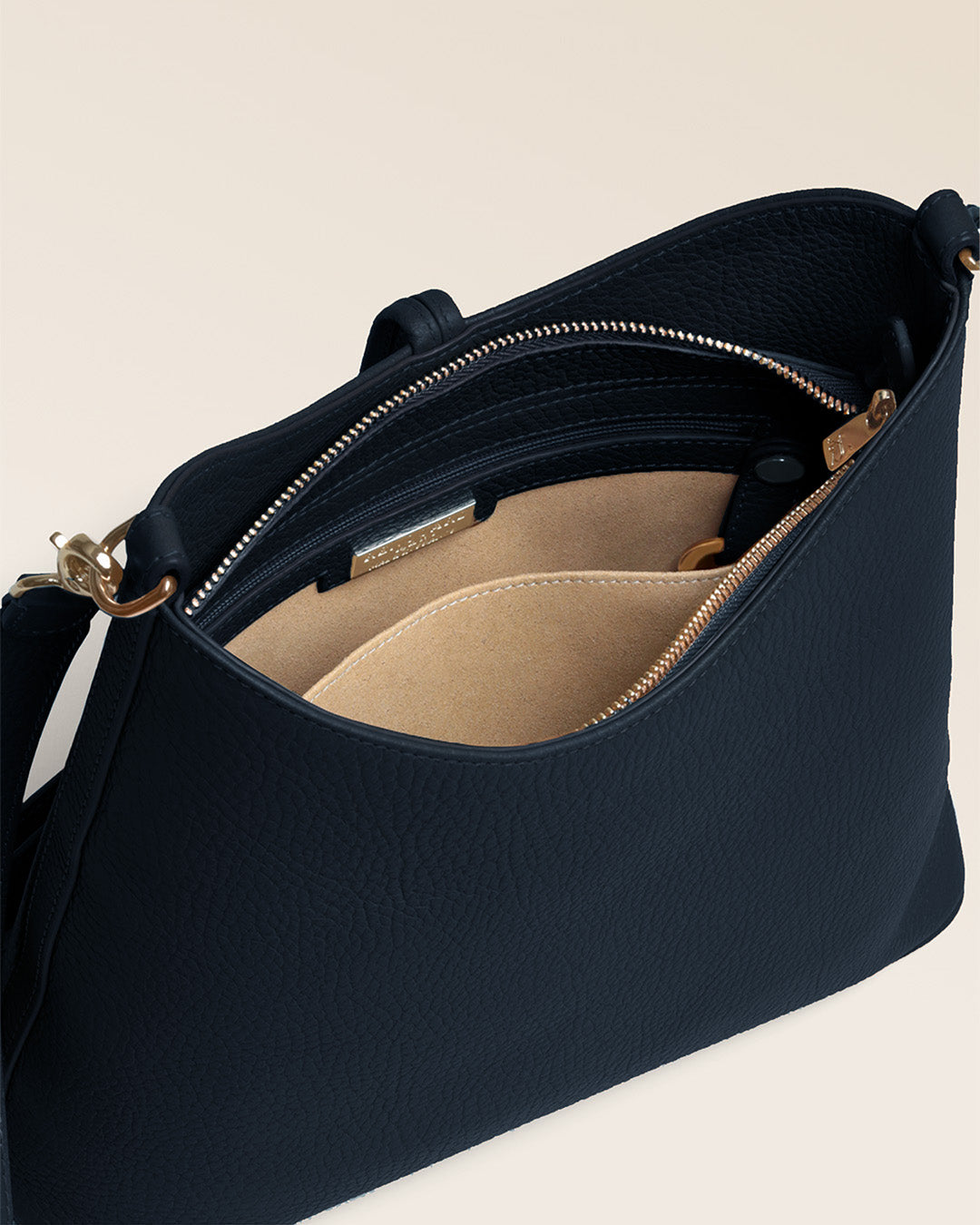 Notre sac Petit Cob Renouard en cuir façon vigogne bleu marine, accessoires dorés et bandoulière cuir ; vu du dessus en studio.