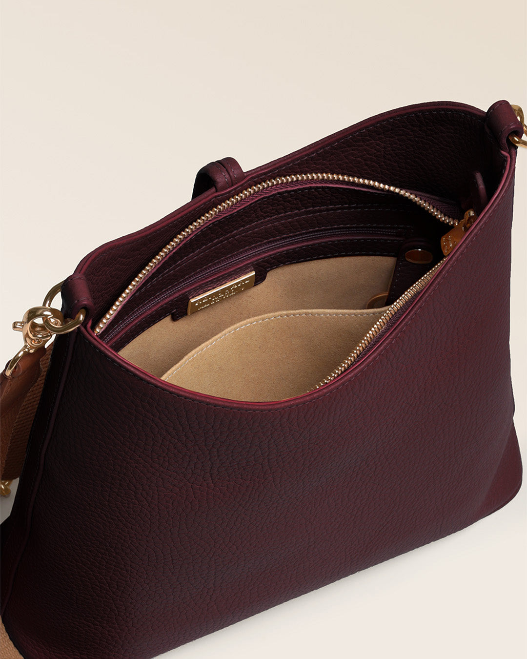 Notre sac Cob Renouard dans sa version Petit modèle, cuir façon vigogne bordeaux et bandoulière coton ; vu du dessus en studio.