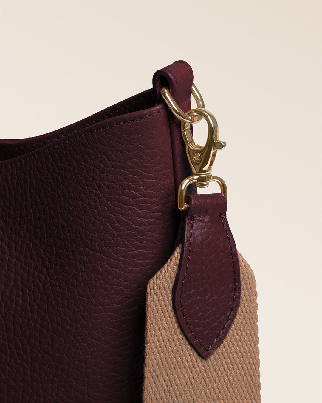 Notre sac Cob Renouard dans sa version Petit modèle, cuir façon vigogne bordeaux et bandoulière coton ; vu de près en studio.