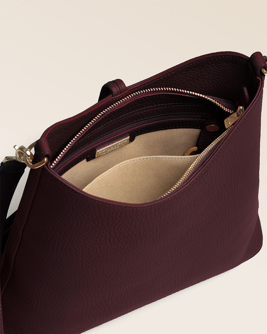 Notre sac Cob Renouard dans sa version Petit modèle, cuir façon vigogne bordeaux et bandoulière cuir ; vu du dessus  en studio.