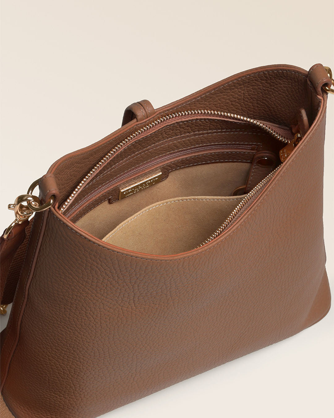 Notre sac Cob Renouard dans sa version Petit modèle, cuir façon vigogne fauve et bandoulière coton ; vu ouvert en studio.