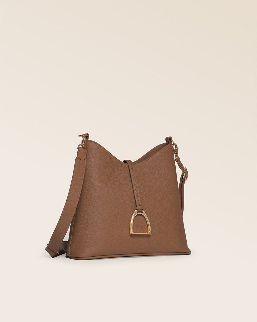 Notre sac Cob Renouard dans sa version Petit modèle, cuir façon vigogne fauve et bandoulière cuir ; vu de quart en studio.