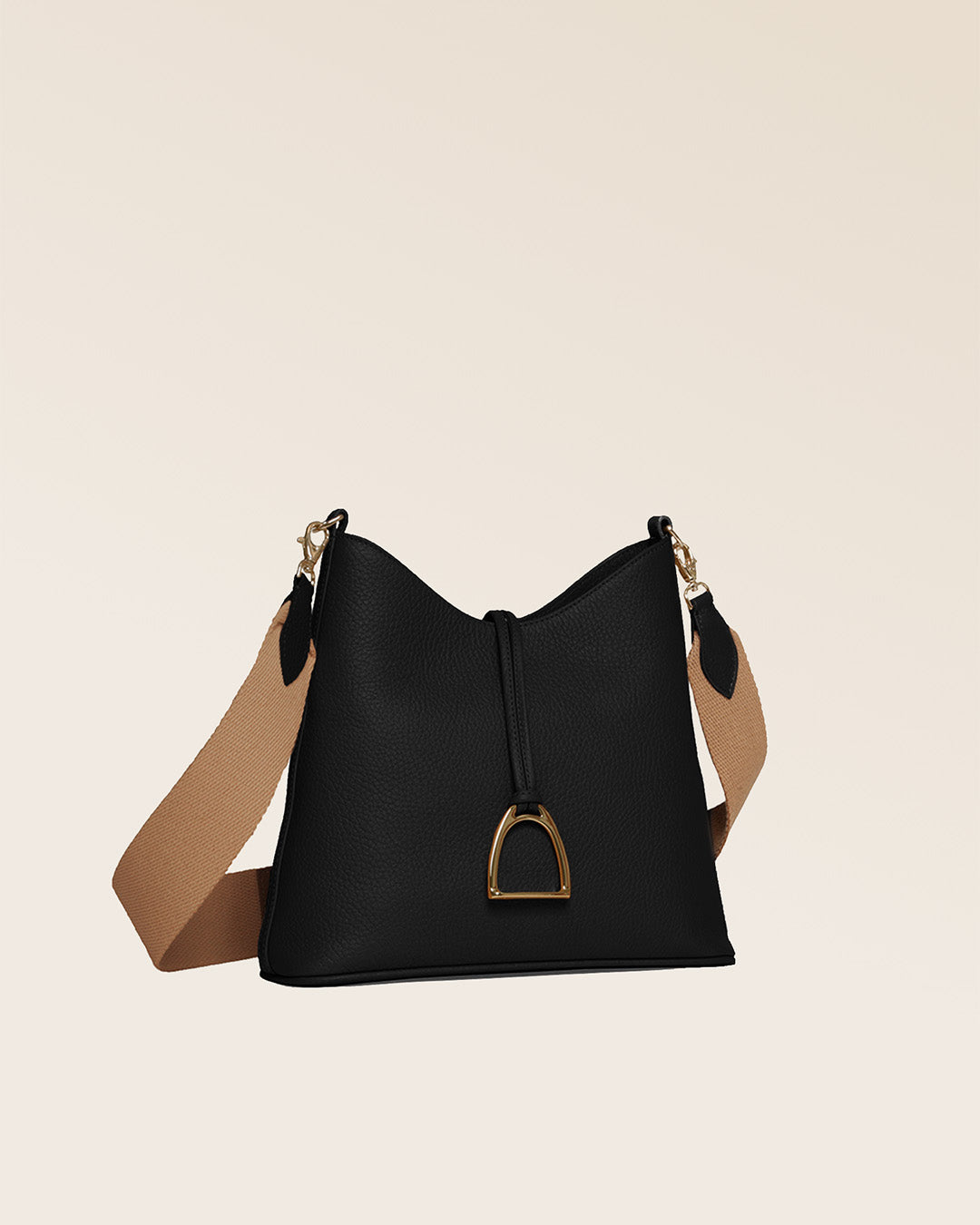 Notre sac Cob Renouard dans sa version Petit modèle, en cuir façon vigogne noir, accessoires dorés et bandoulière coton ; vu de quart en studio.