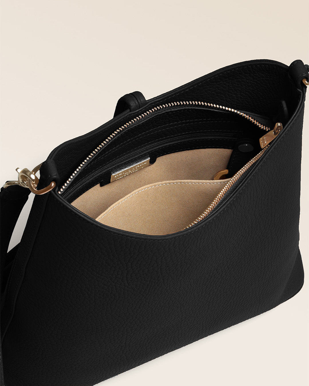 Notre sac Cob Renouard dans sa version Petit modèle, en cuir façon vigogne noir, accessoires dorés et bandoulière cuir ; vu du dessus en studio.