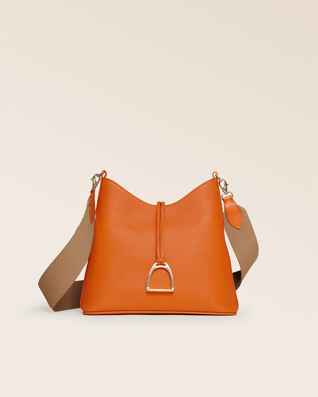 Notre sac Cob Renouard dans sa version Petit modèle, en cuir façon vigogne orange, accessoires dorés et bandoulière coton ; vu de face en studio.