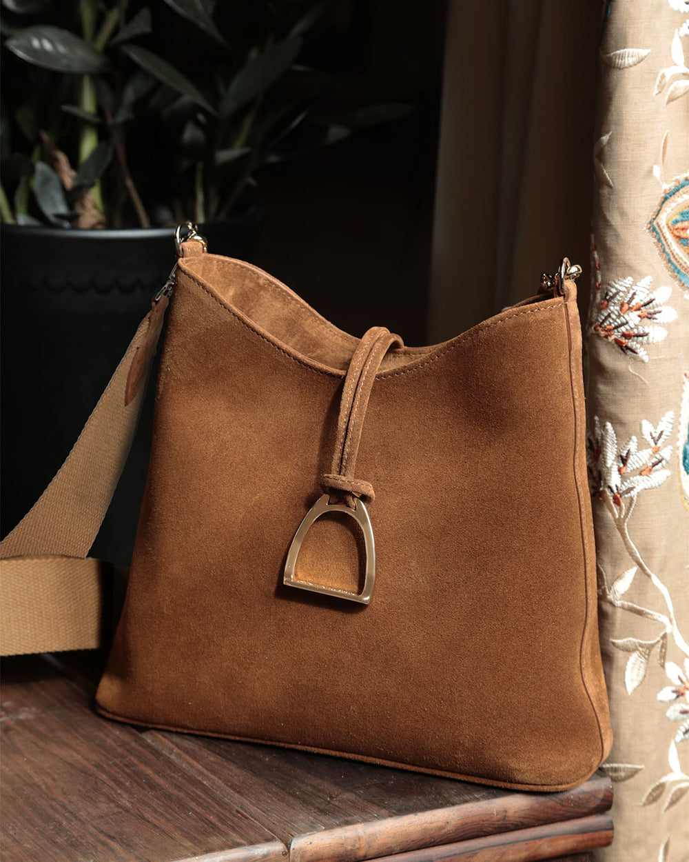 Notre sac Cob Renouard dans sa version petit modèle, cuir veau velours noisette et bandoulière coton camel ; vu en ambiance.