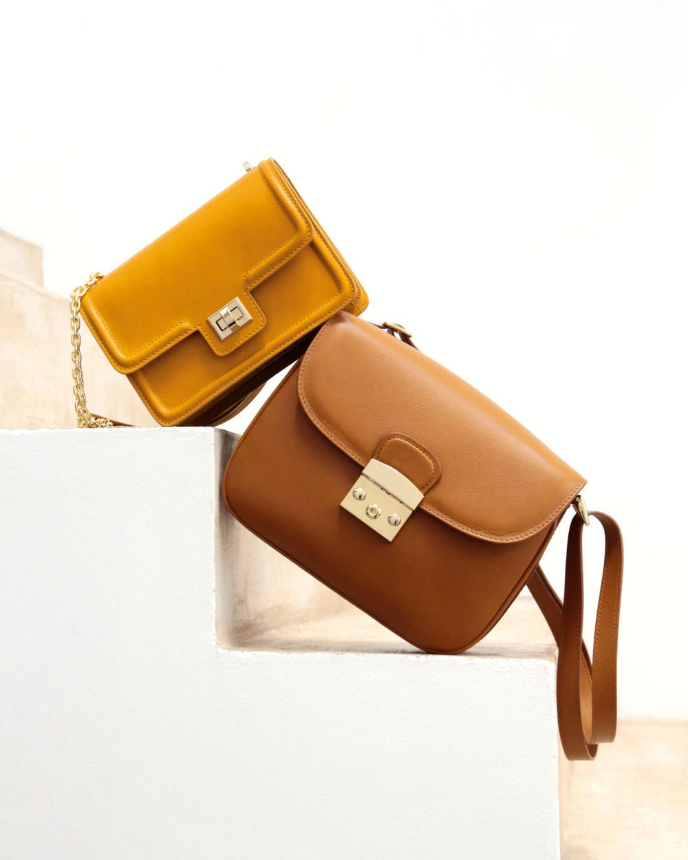 Notre sac Cornouaille en cuir vintage camel vu de face, dans des escaliers.