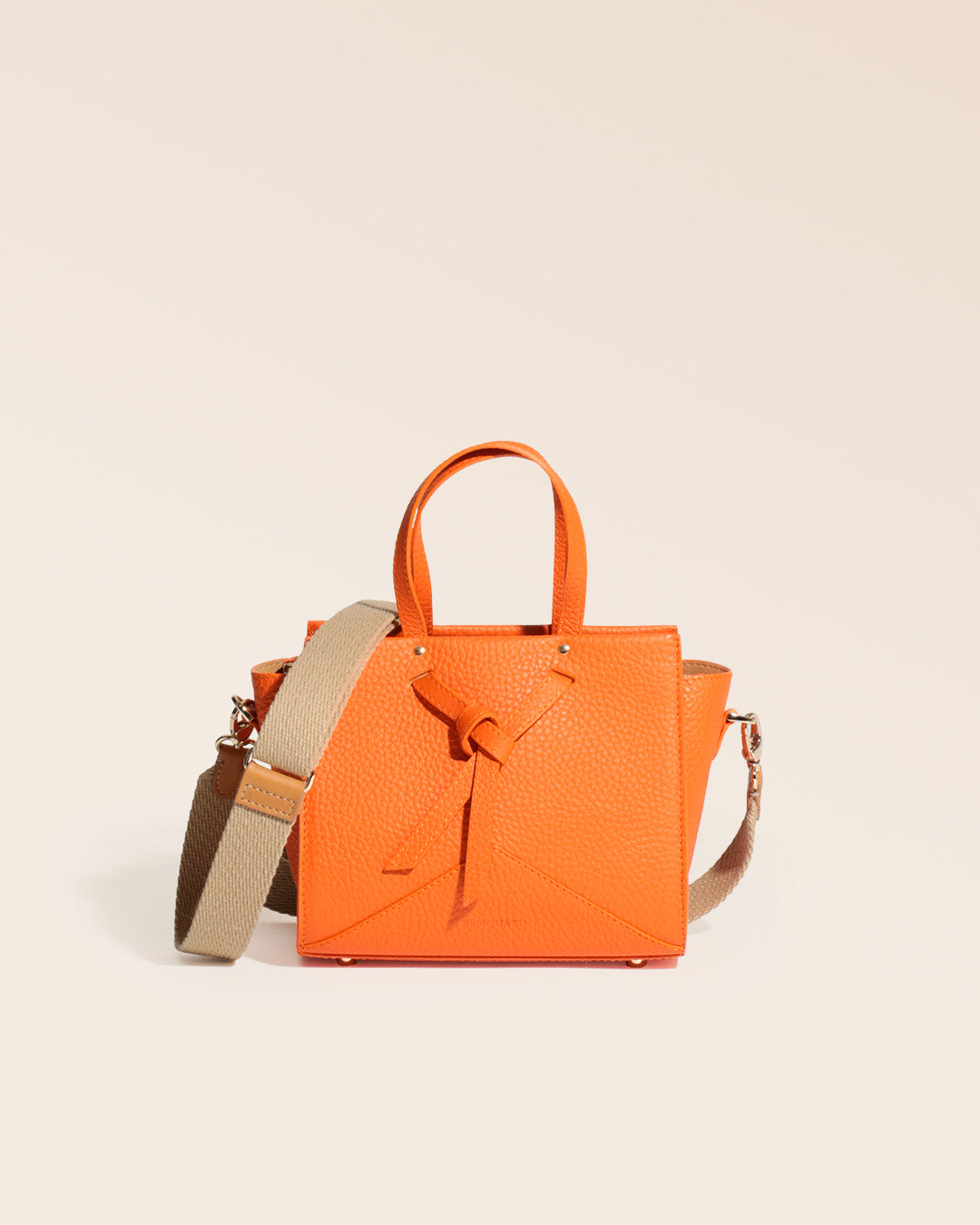 Notre sac Croisière en cuir façon vigogne orange et bandoulière coton sable, vu de face en studio.