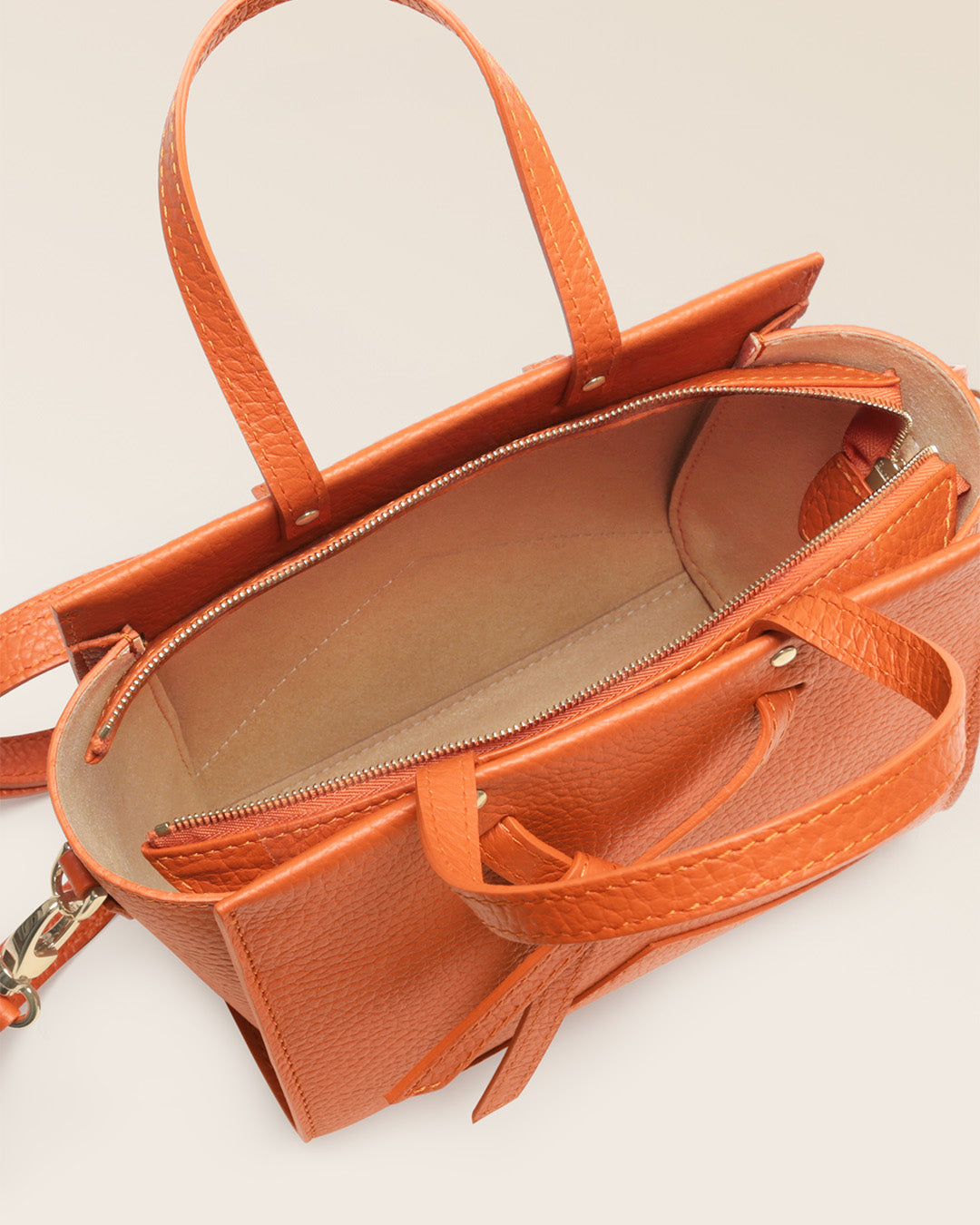 Our Renouard Croisière bag in orange vicuña-style leather, seen from above in the studio.