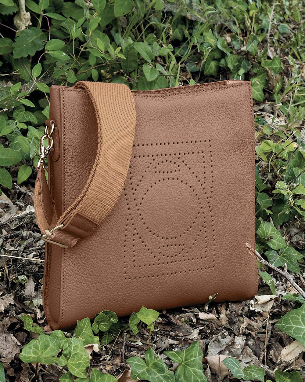 Le sac Mini Étrivière Renouard en cuir façon vigogne fauve et sa bandoulière coton camel, vu de quart en ambiance.