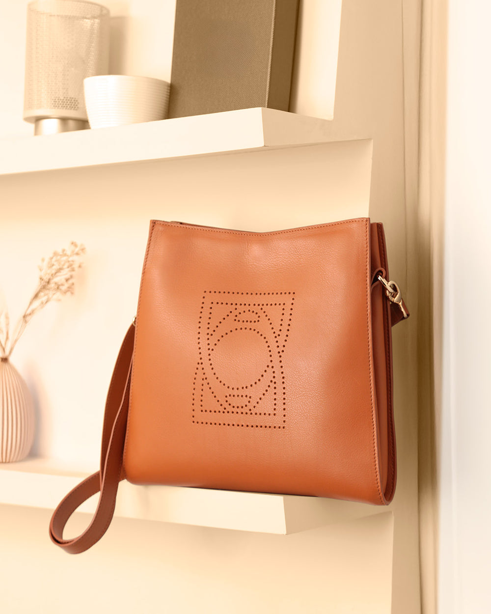Notre sac Étrivière en cuir vintage camel vu de quart en ambiance.