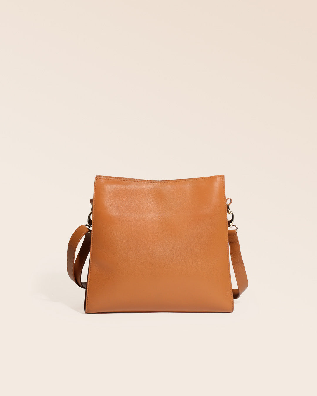 Notre sac Étrivière en cuir vintage camel et bandoulière cuir amovible vu de dos en studio.