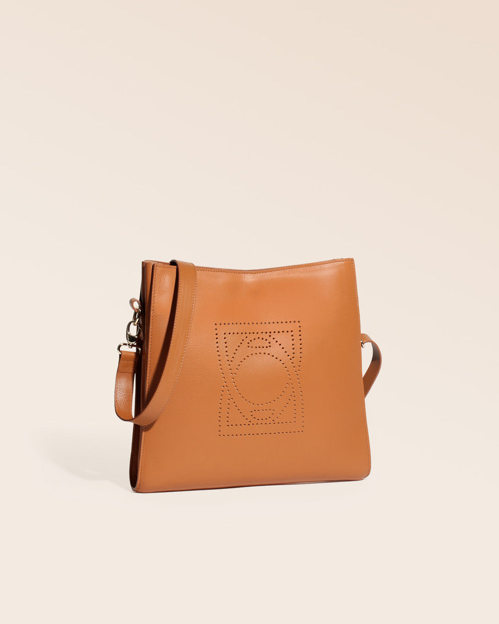 Notre sac Étrivière en cuir vintage camel et bandoulière cuir amovible vu de quart en studio.
