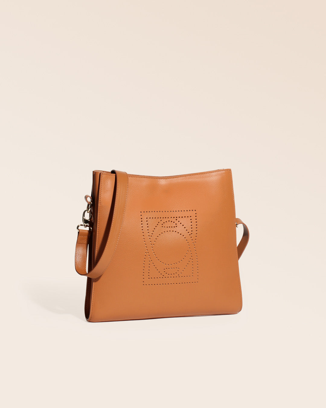 Notre sac Étrivière en cuir vintage camel et bandoulière cuir amovible vu de quart en studio.