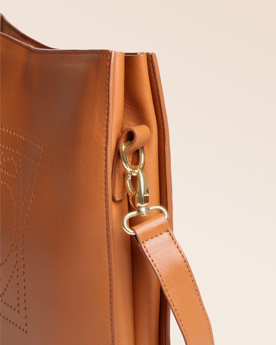 Notre sac Étrivière en cuir vintage camel et bandoulière cuir amovible vu en détail en studio.