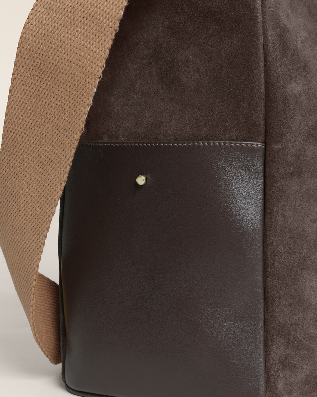 Le sac Gaspard Renouard en cuir veau velours espresso et lisse ébène, avec sa bandoulière coton camel, vu en détails en studio.