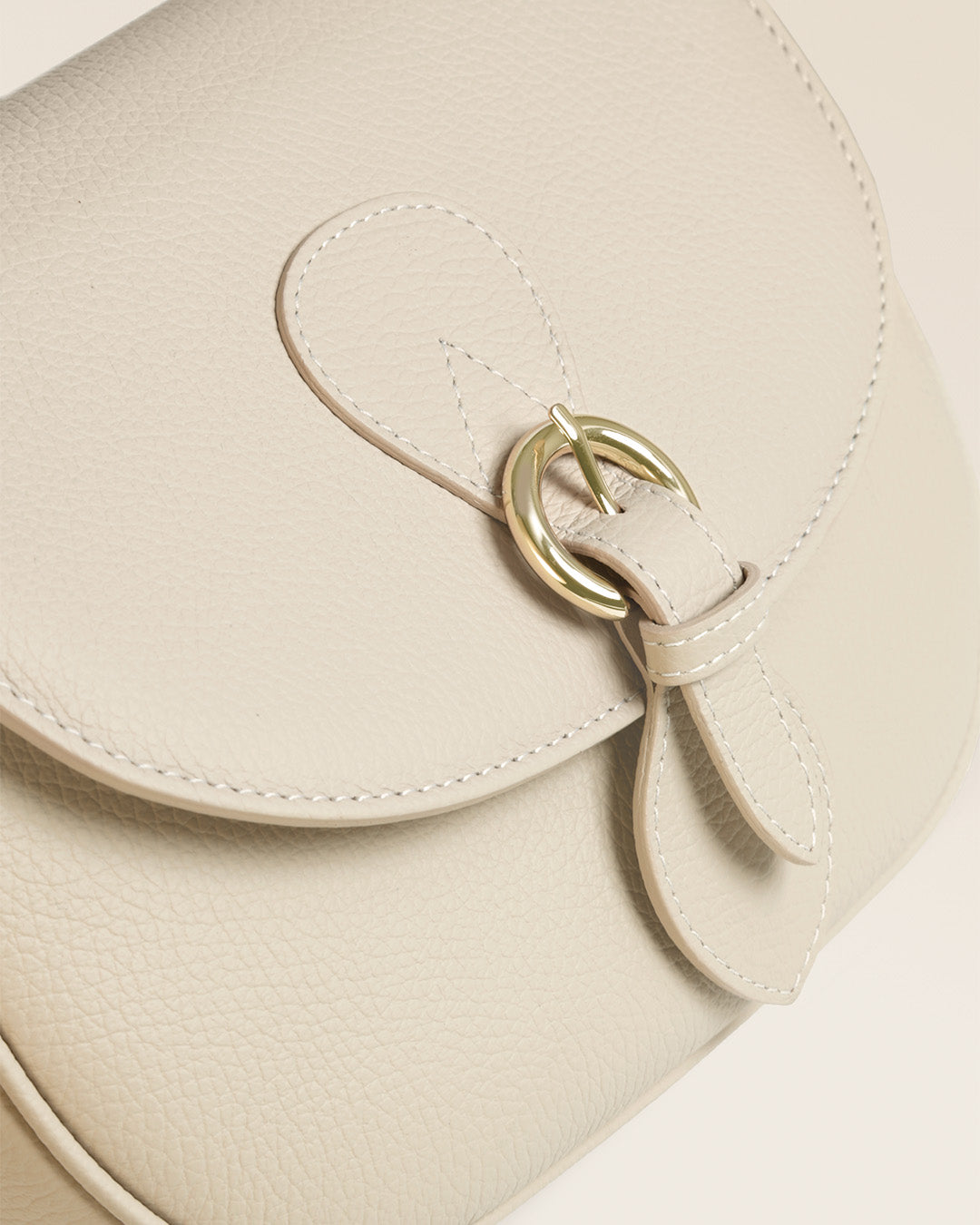 Notre sac gibecière Léa Renouard en cuir façon vigogne crème, vu de près en studio.