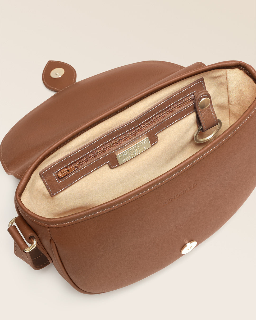 Notre sac gibecière Léa Renouard en cuir vintage camel, vu ouvert en studio.