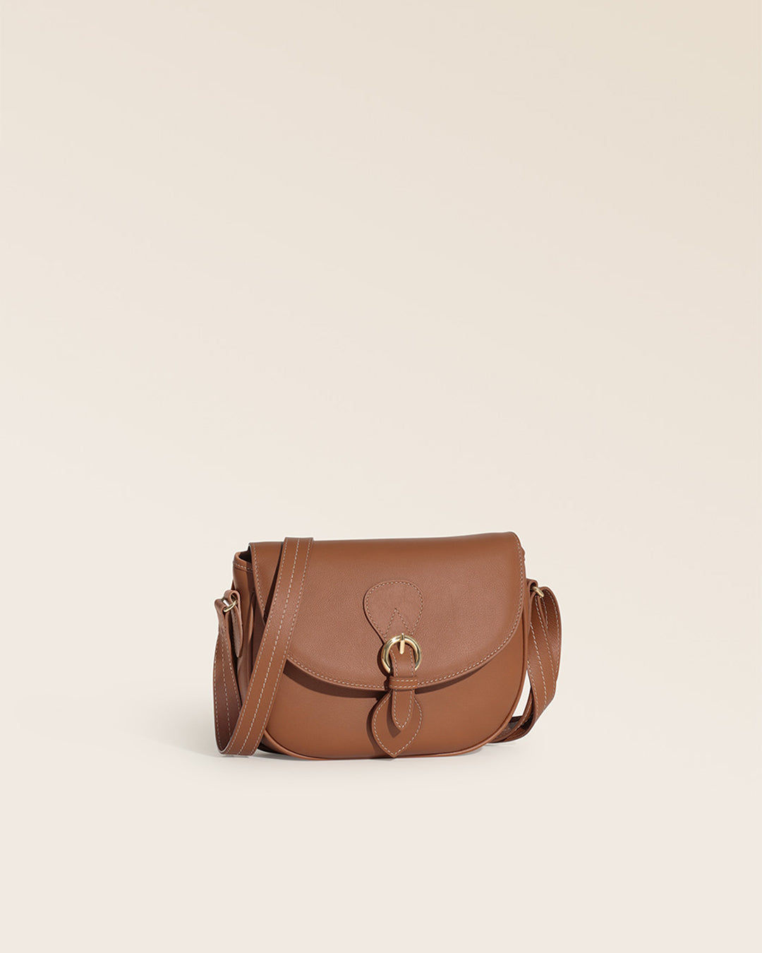 Notre sac gibecière Léa Renouard en cuir vintage camel, vu de quart en studio.