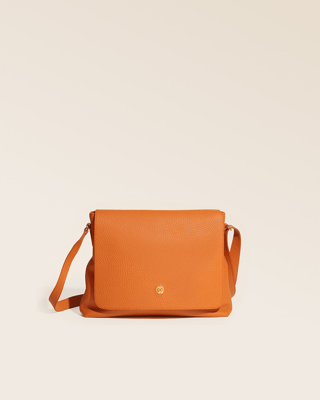 Our Gwenn bag in orange vicuña-style leather, seen from the front in the studio.