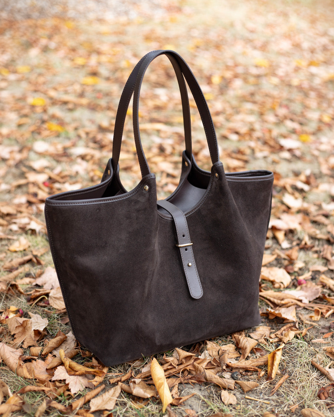 Le sac Hunter Renouard en cuir veau velours espresso et cuir lisse ébène, vu de quart en ambiance.