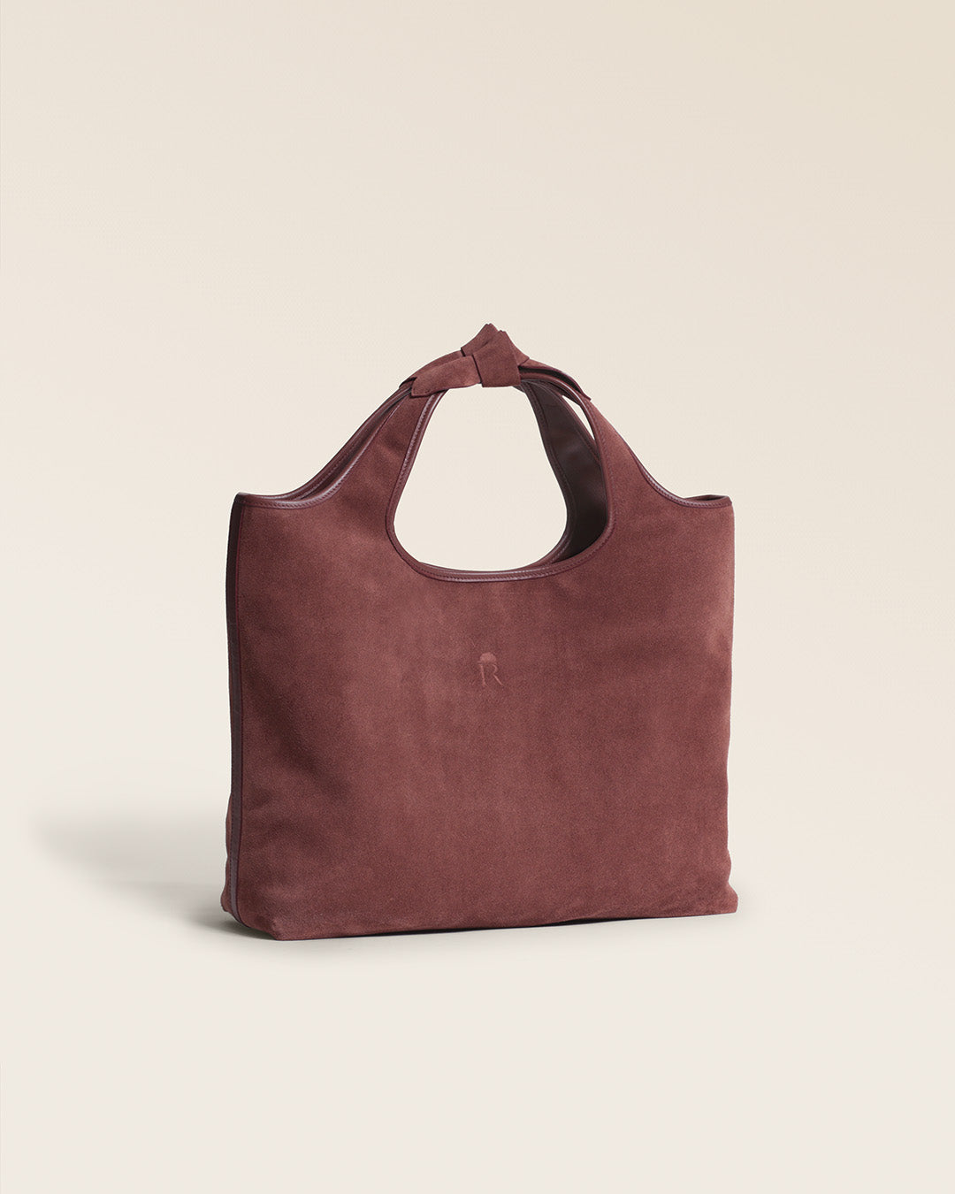 Le sac Jaipur Renouard en cuir veau velours acajou et ses poignées à noeuds, vu de quart en studio.