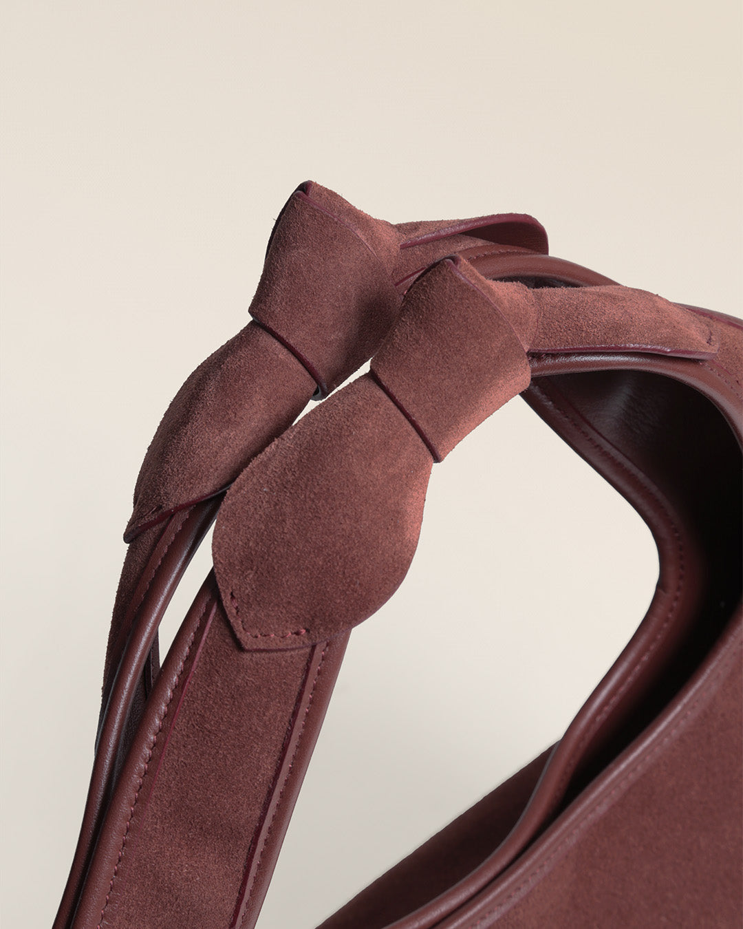 Le sac Jaipur Renouard en cuir veau velours acajou et ses poignées à noeuds, vu de près en studio.