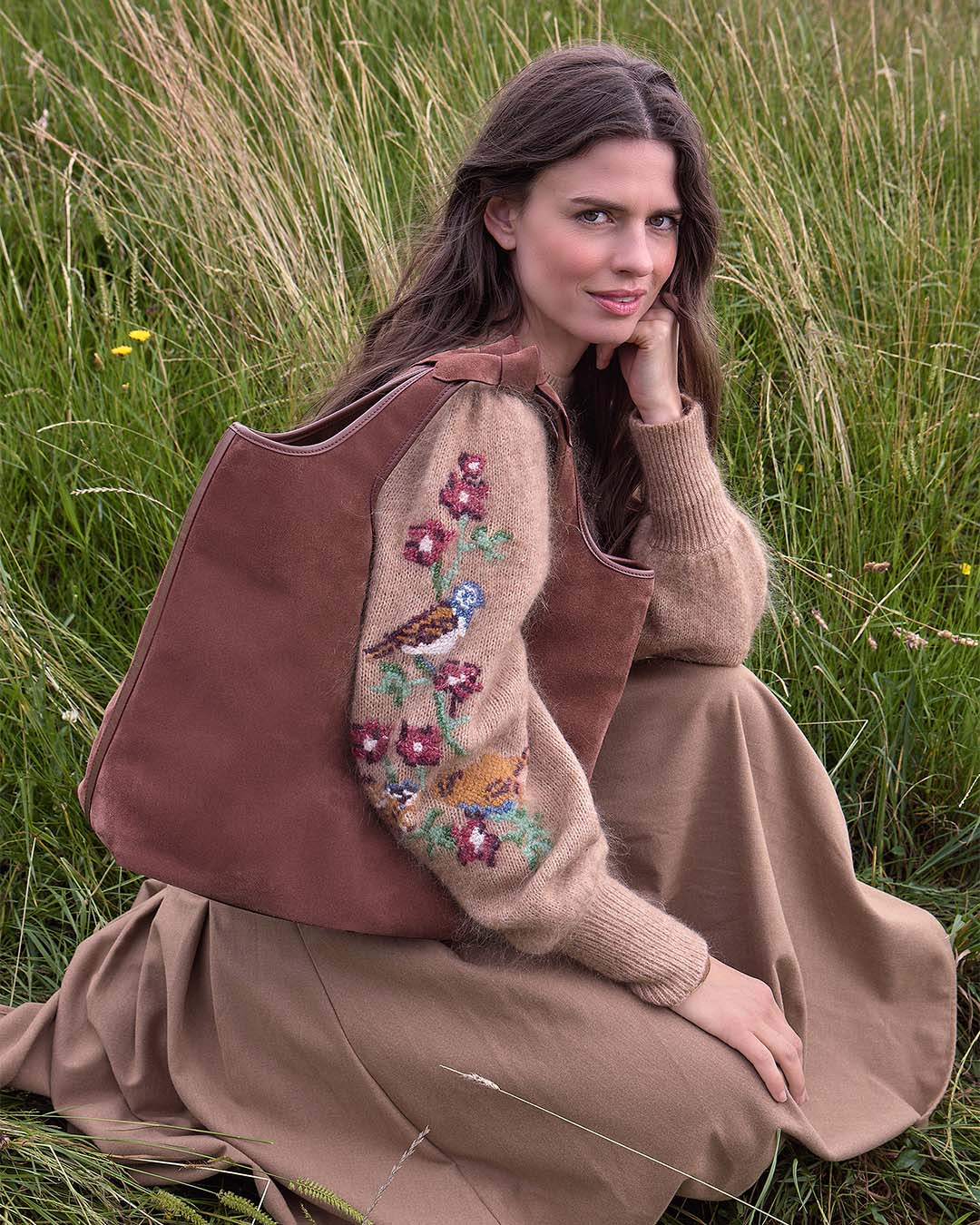 Le sac Jaipur Renouard en cuir veau velours acajou et ses poignées à noeuds, vu porté par notre mannequin.
