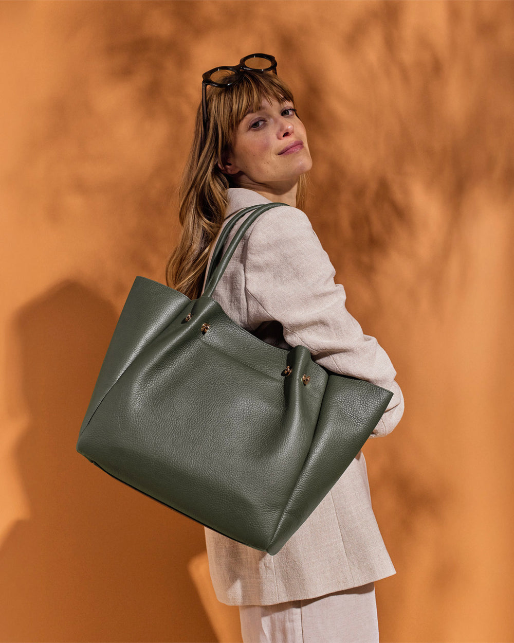 Notre sac Josepha Renouard en cuir façon vigogne kaki, porté par notre mannequin.