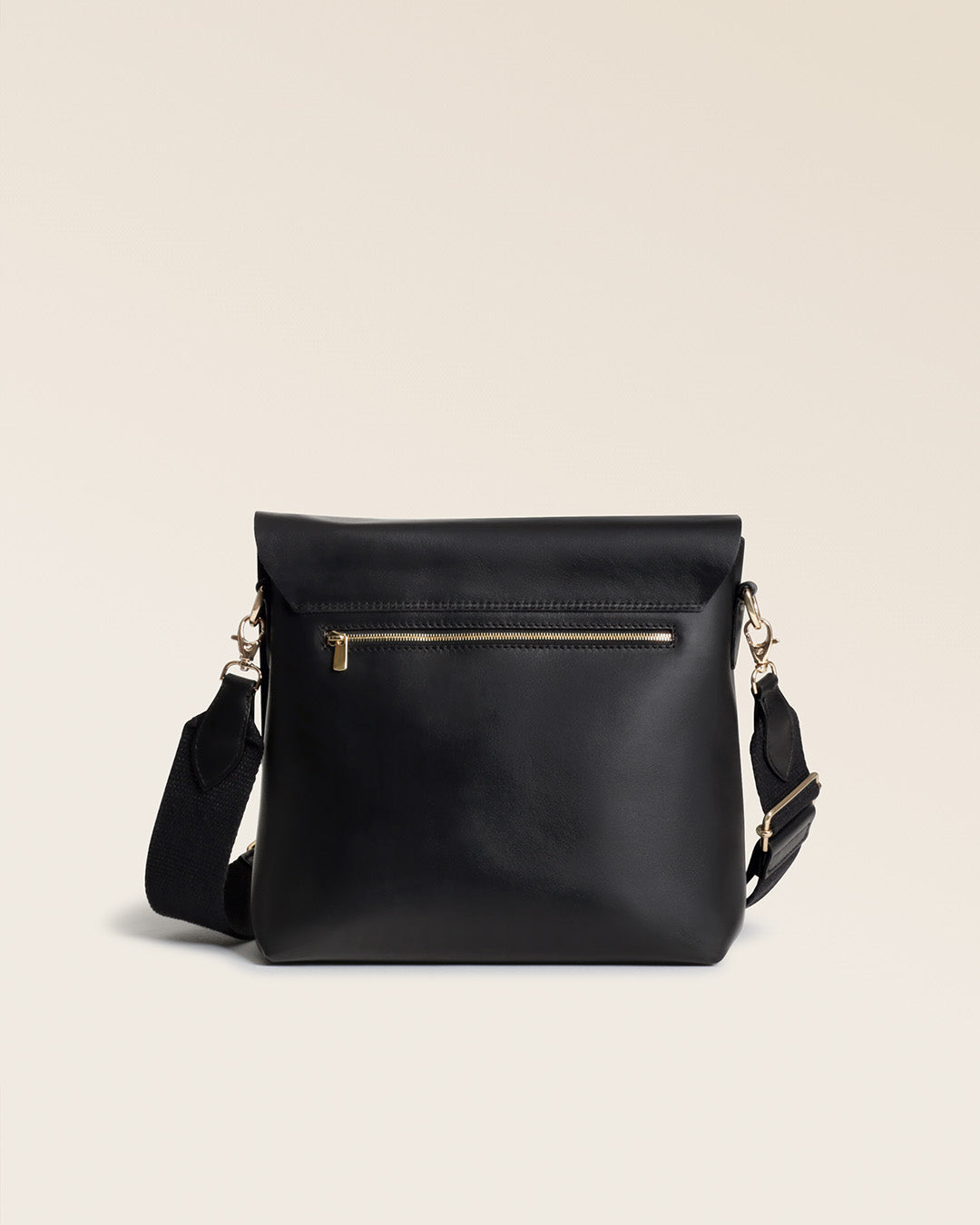 Le sac Joy Renouard en cuir lisse noir avec sa bandoulière en coton, vu de dos en studio.