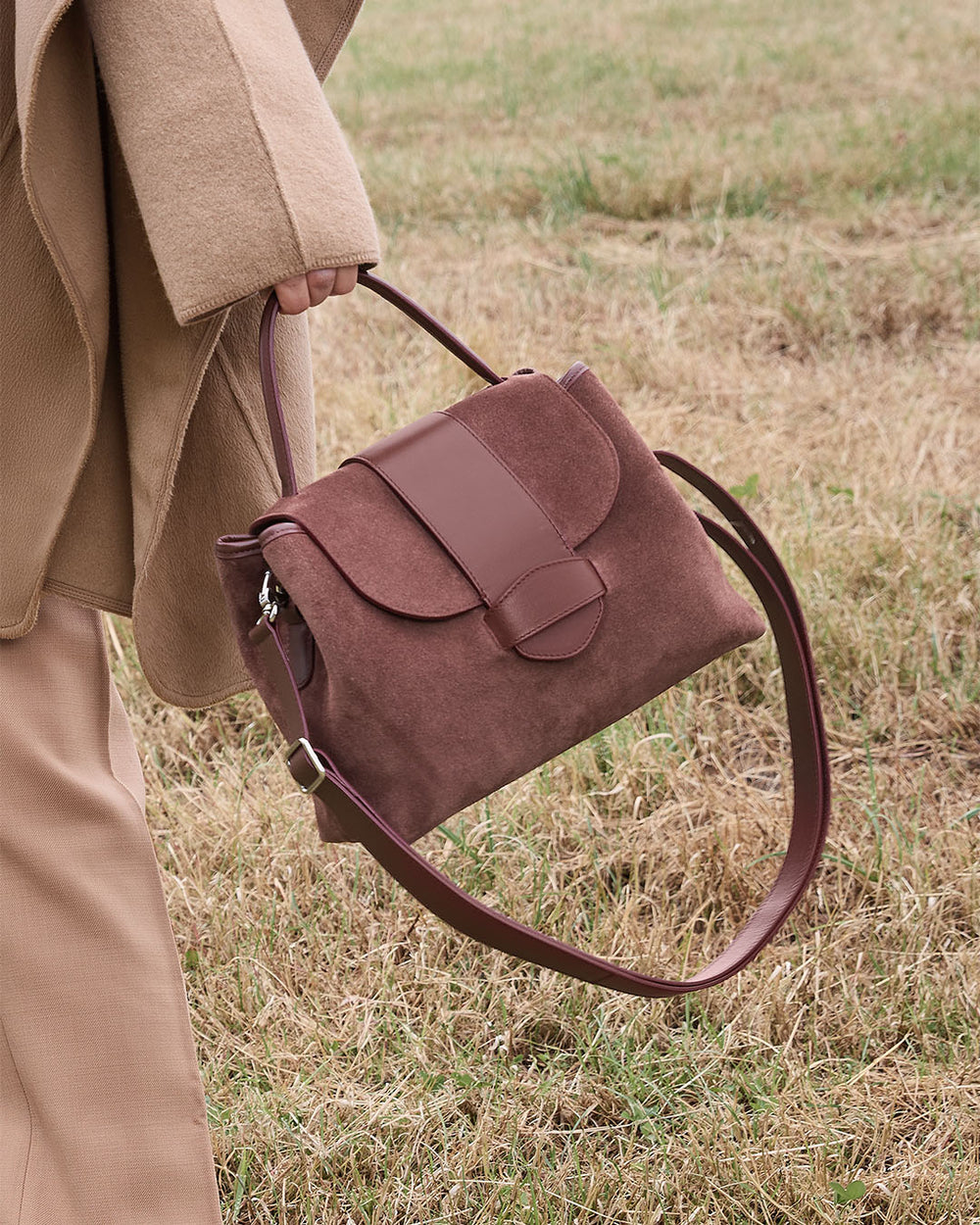 Le sac Kimono Renouard en cuir veau velours acajou et cuir lisse acajou, vu porté par notre mannequin.
