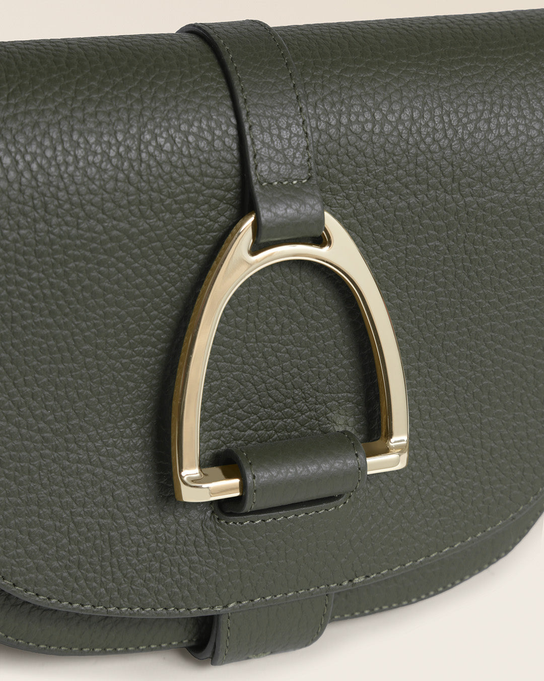 Le sac Licol Renouard en cuir façon vigogne kaki et son étrier doré pâle, vu de près en studio.